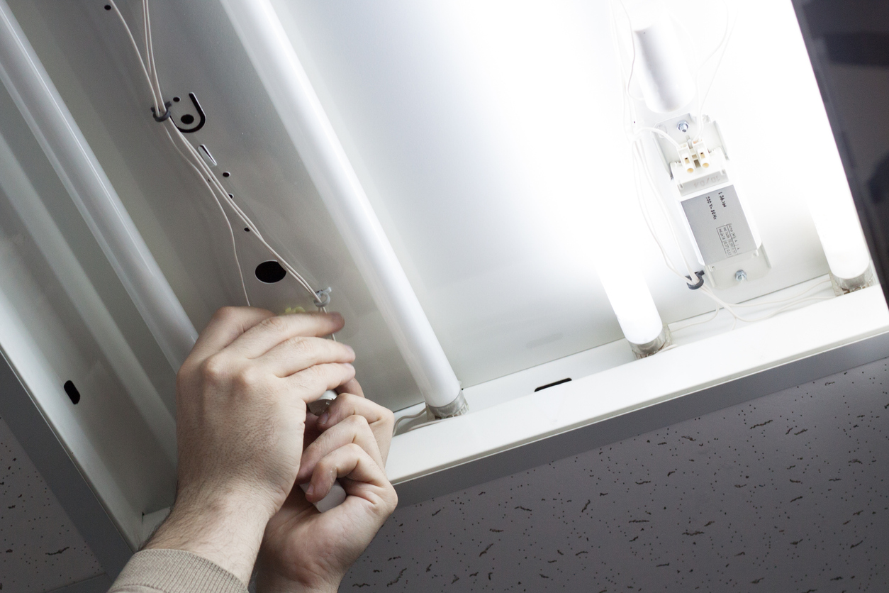 An electrician install the light under cabinet