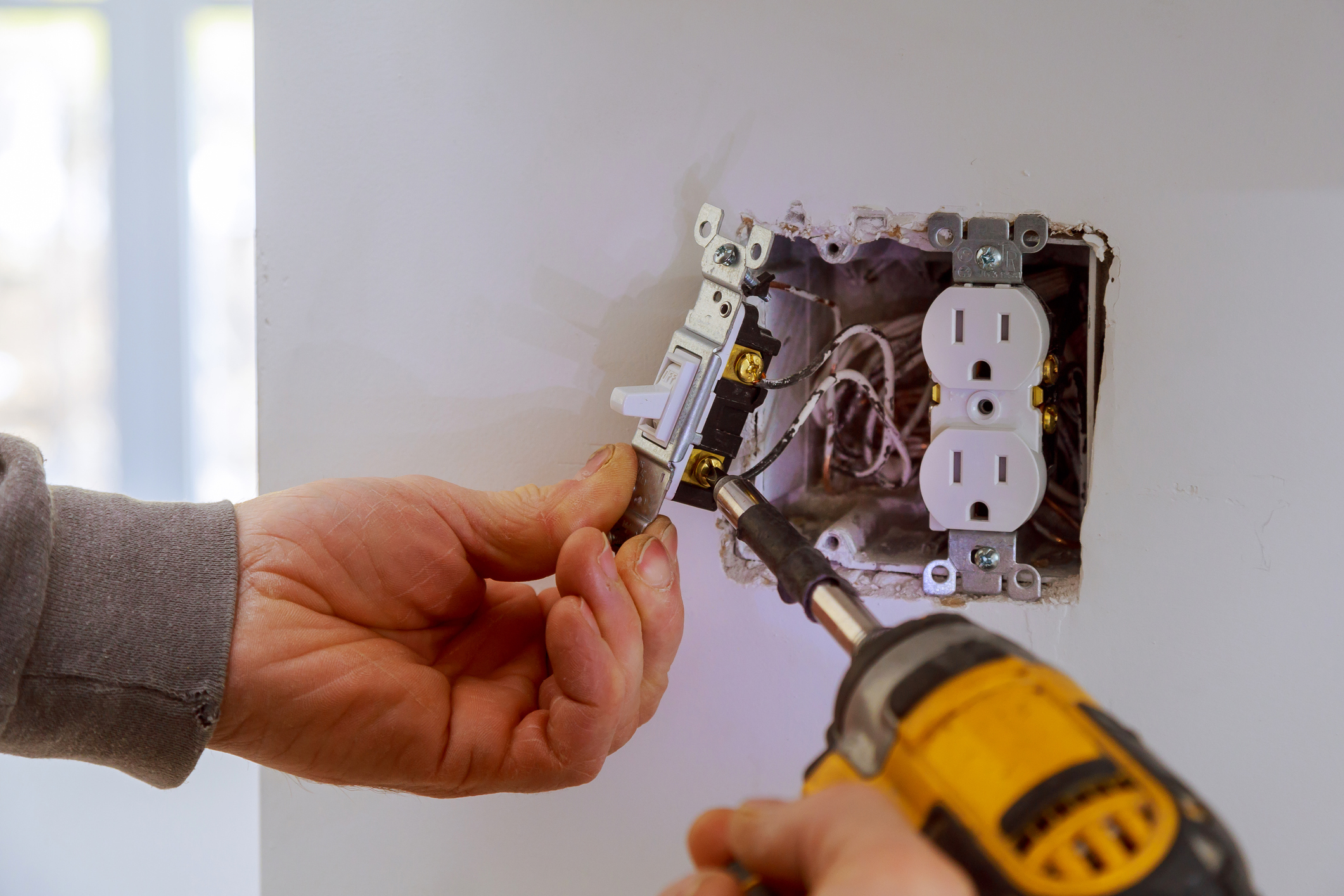 The electrician repair a power switch to the electrical junction box