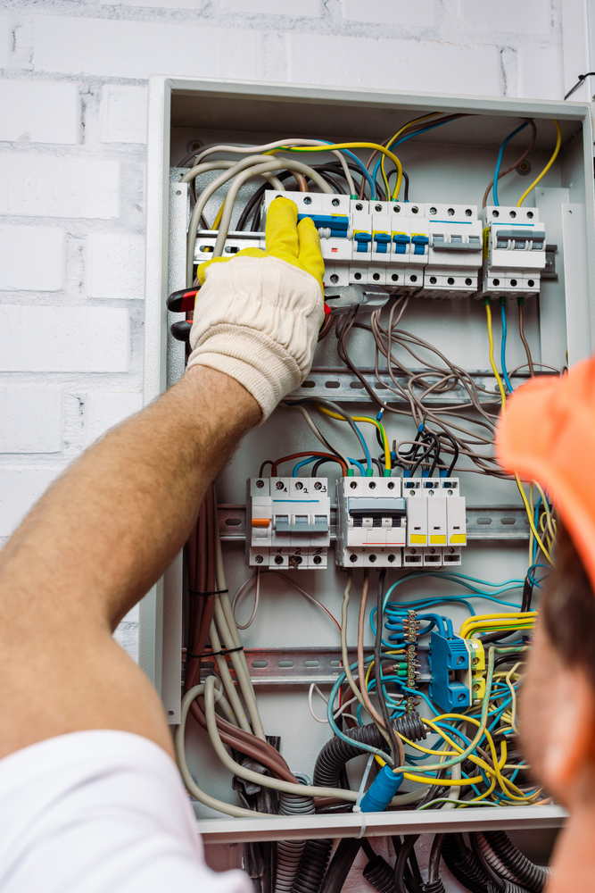 Licensed electrician inspecting a Cave Spring electrical panel before hot tub and pool installation